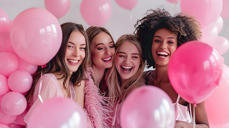 Mädchengruppe mit rosa Luftballons