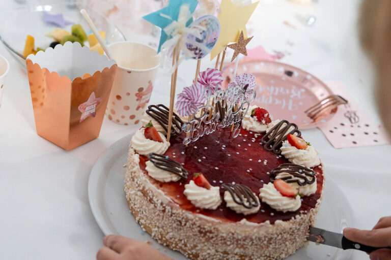 Erdbeertorte beim Anschneiden mit Dekoration